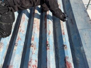 一宮市 折半屋根 ケレン作業中 職人が旧塗膜・錆を丁寧に除去している様子