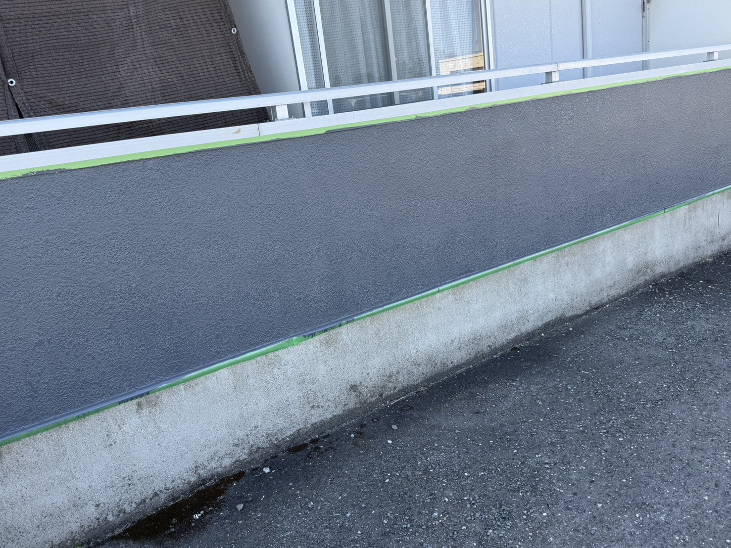 大垣市アパート外壁塗装 中塗り完了|ベランダ腰壁にグレー系塗料を均一に塗布した状態
